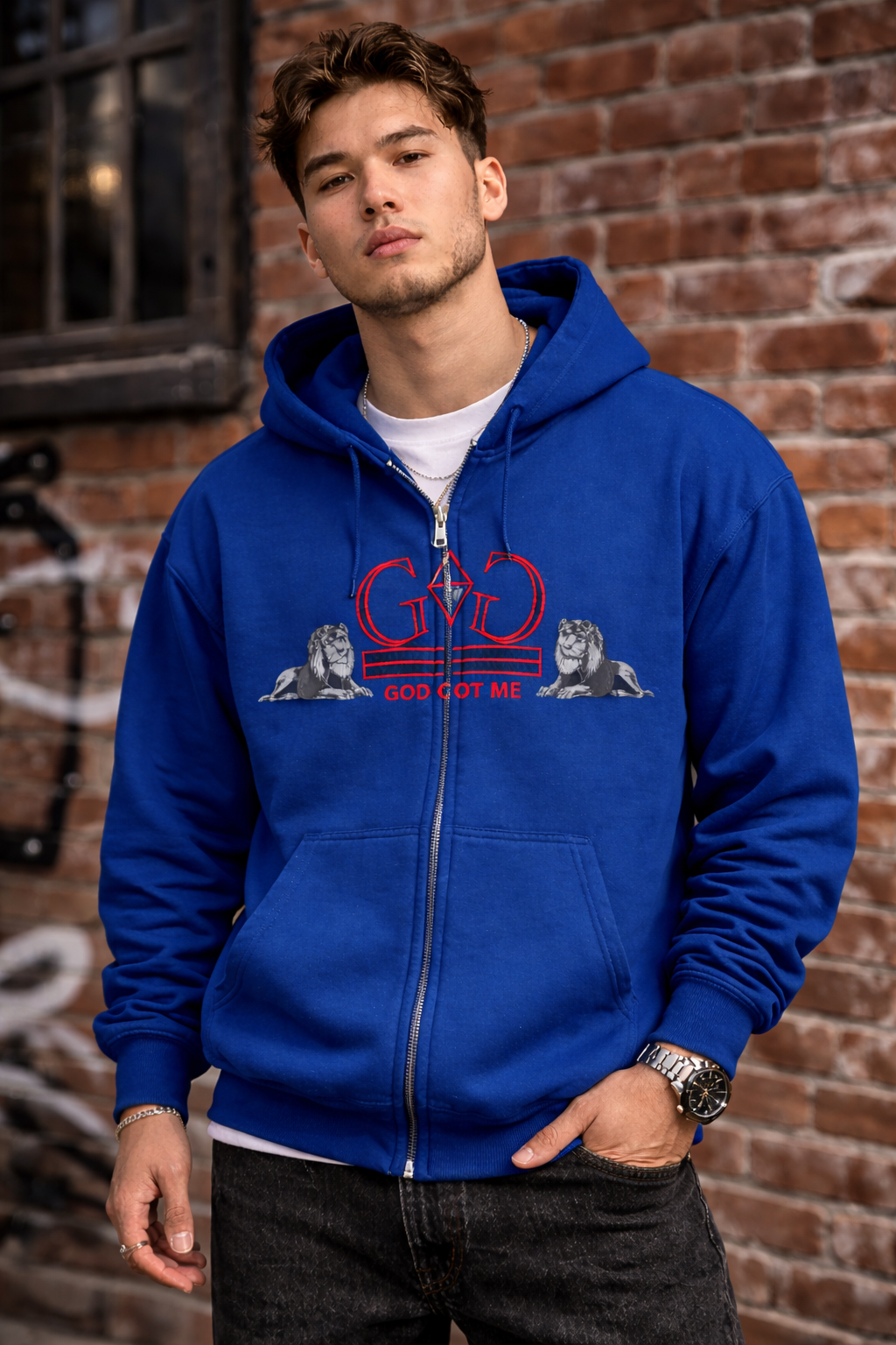 Man wearing a blue hoodie with a logo and text against a brick wall.